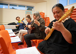 A picture of ladies learning to play ukulele