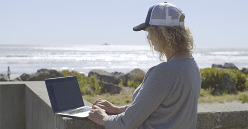 Woman-on-laptop-at-beach