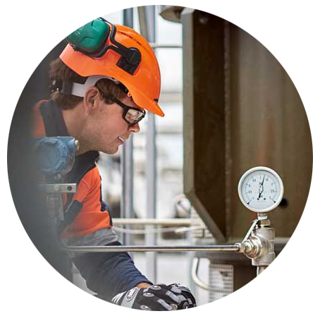 Photo cropped into a circle of a person in PPE looking at a pressure device