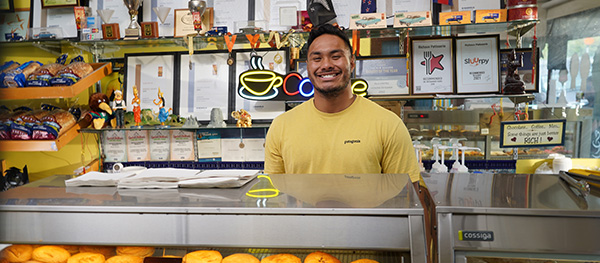 Small_business_day_man_standing_behind_counter_smiling