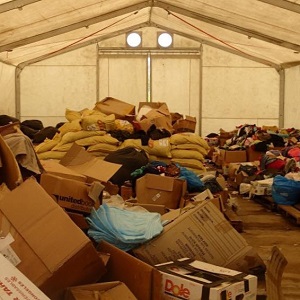 Unrequested goods are piled up in a storage tent in Vanuatu, following Tropical Cyclone Pam in 2015. When donating to disaster relief it's best only to send goods that have been requested by agencies on the ground - as other items can take up valuable transport and storage resources. In most cases, financial support is the best way to help. (Image courtesy of the National Disaster Management Office, Vanuatu)