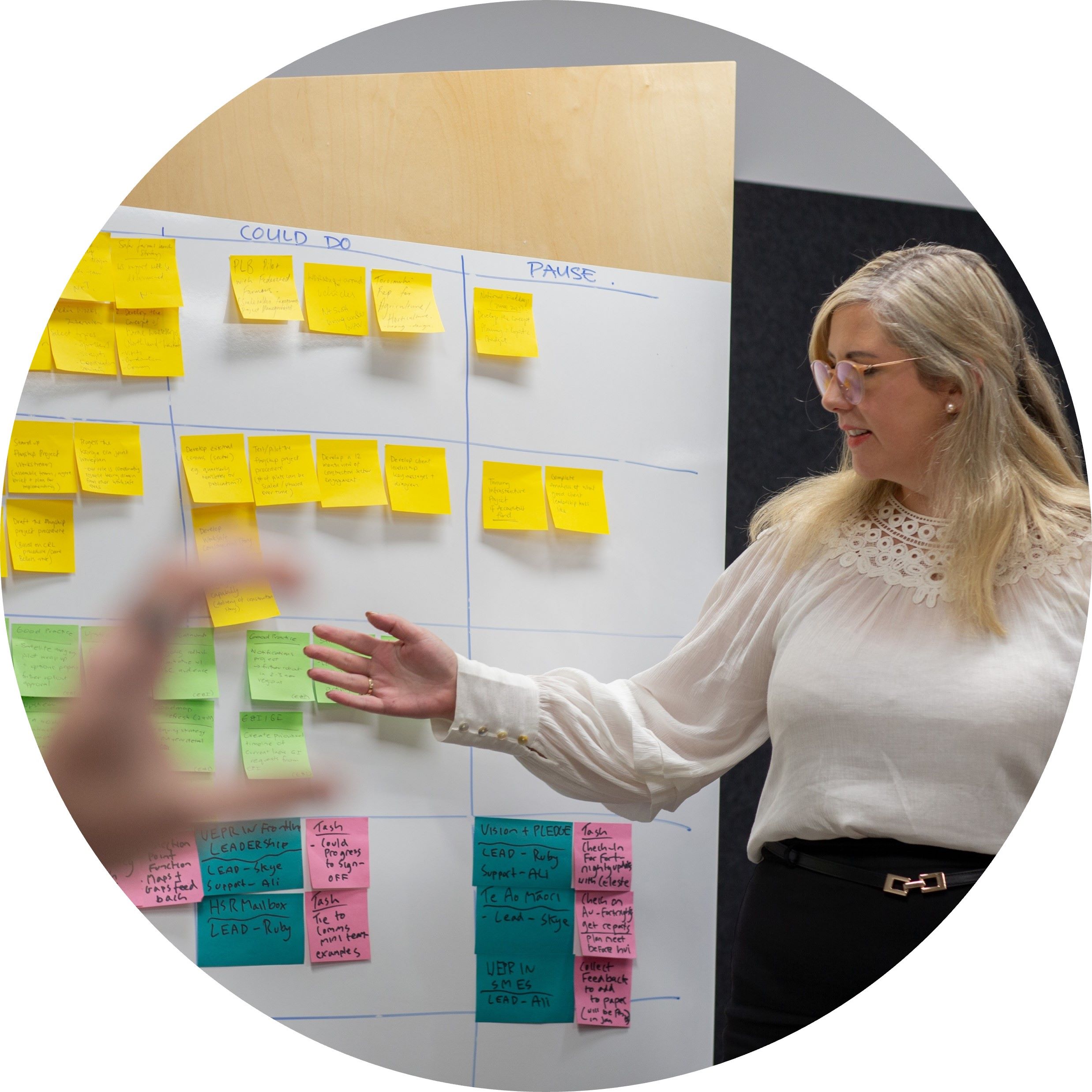 woman pointing to post it notes in a workshop